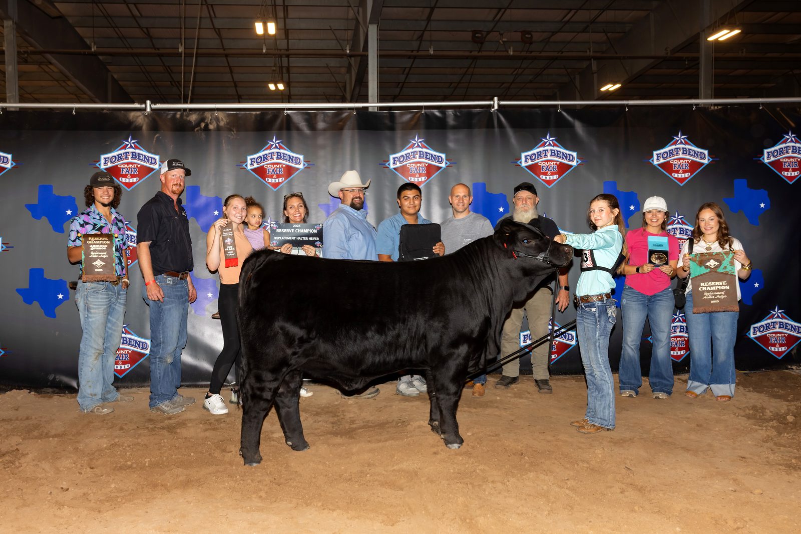 Ella, her heifer, and the whole crew celebrating the Reserve Champion Replacement Halter Heifer win at the Fort Bend County Fair